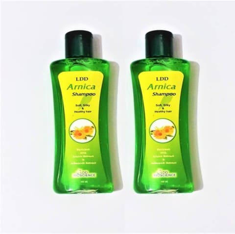 Two bottles of LDD Arnica Shampoo displayed, featuring a vibrant green design and highlighting benefits for soft, shiny, and healthy hair.