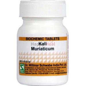 A white cylindrical bottle labeled "Kali Muriaticum" containing biochemic tablets, produced by Dr. Willmar Schwabe India Pvt. Ltd.
